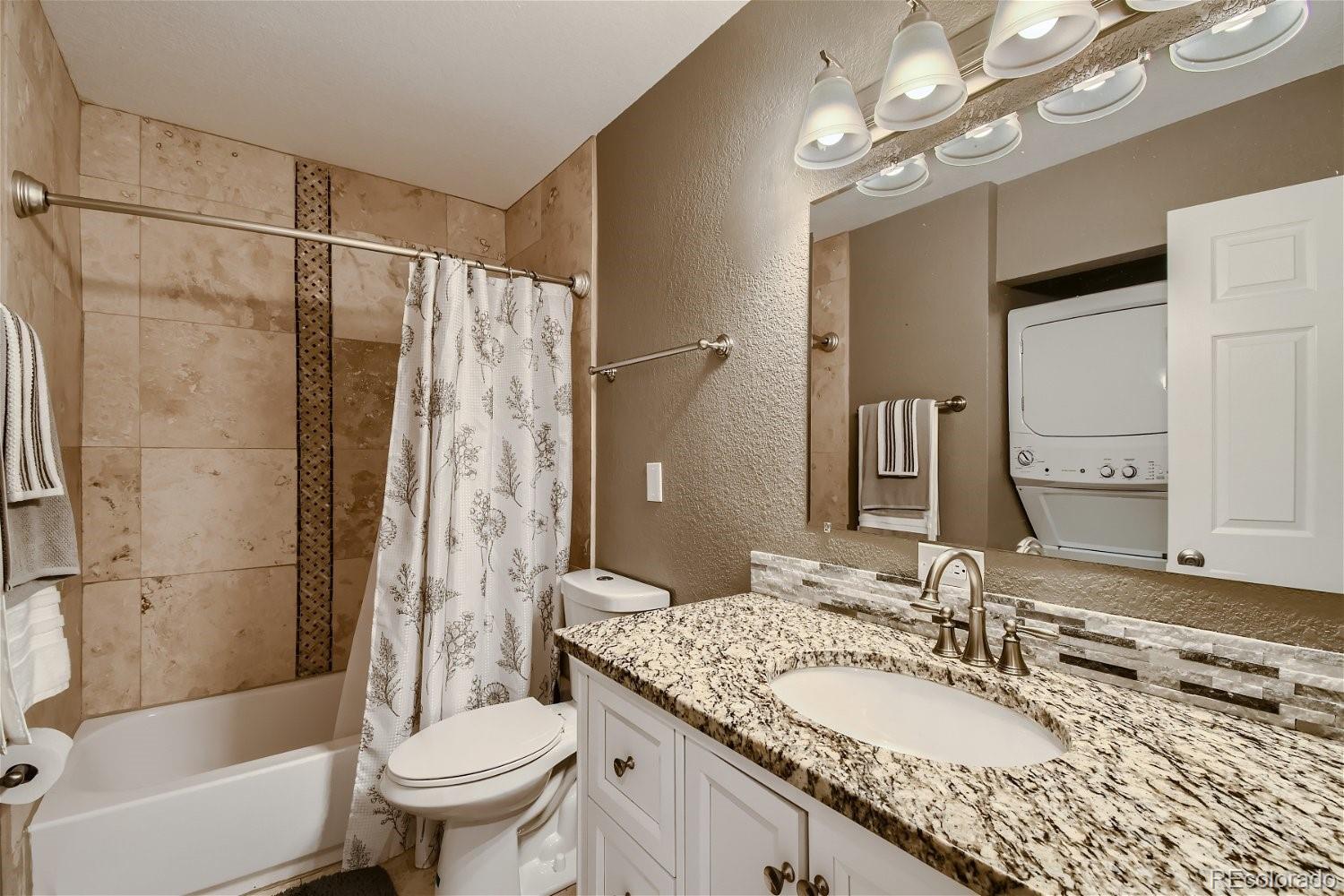 8207 High Street Denver, CO 80229 - Photo 10 of 11 a bathroom with a granite countertop shower sink vanity mirror and toilet