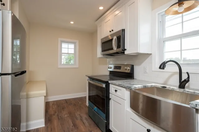 a kitchen with stainless steel appliances granite countertop a stove a sink and a microwave