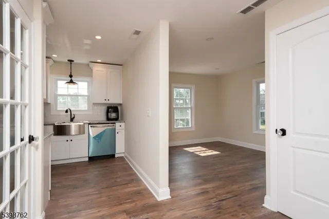 a view of a kitchen with a refrigerator a stove top oven and cabinets
