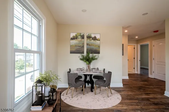 a dining room with furniture potted plants and wooden floor