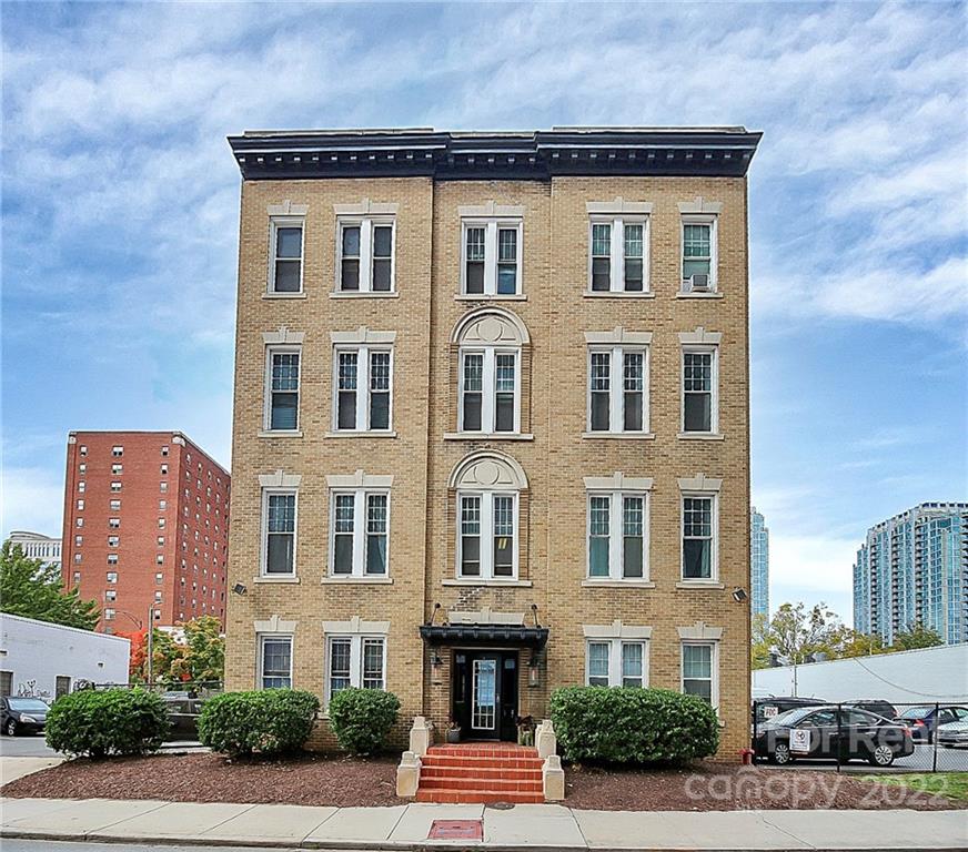 508 North Tryon Street, Unit 116 Charlotte, NC 28202 - Photo 2 of 4 a front view of a residential apartment building with a yard