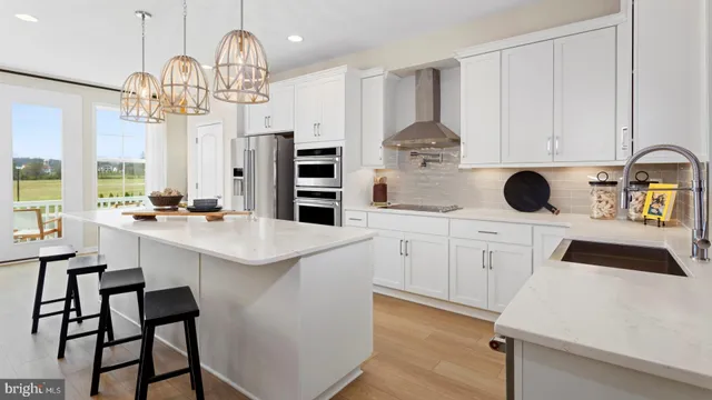 a kitchen with a sink dishwasher and white cabinets with wooden floor