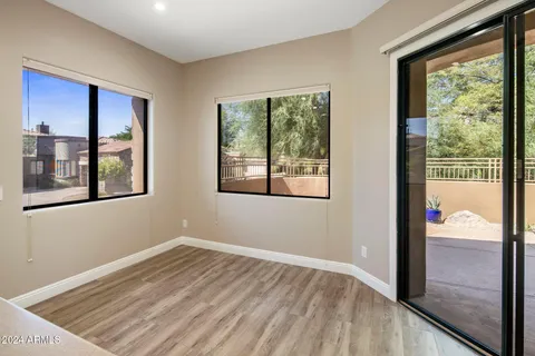 a view of a bedroom with wooden floor and windows