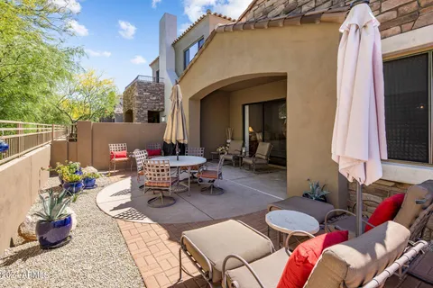 a view of a patio with couches table and chairs and potted plants
