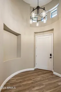 a view of wooden floor and a chandelier in a room