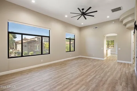a view of an empty room with window and wooden floor