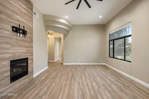 an empty room with windows and a fireplace