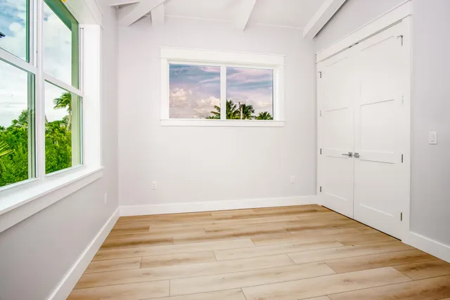 a view of a room with wooden floor and a window