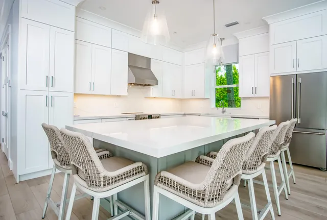 a kitchen with stainless steel appliances a table chairs and a refrigerator