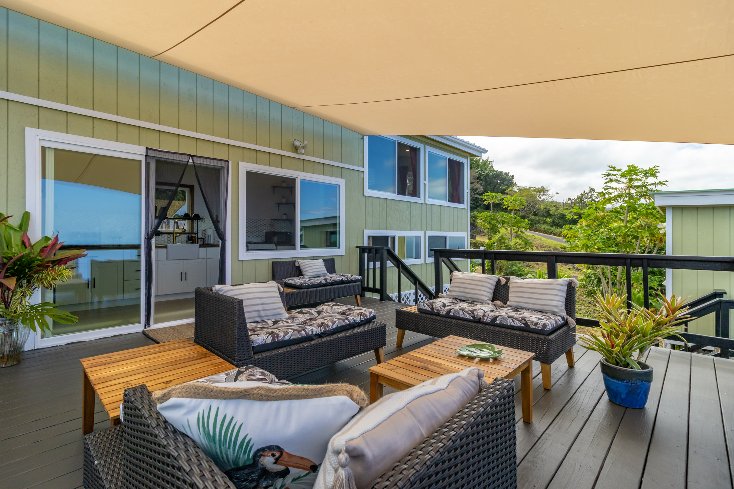 87-2793 Hawaii Belt Road Captain Cook, HI 96704 - Photo 14 of 30 a view of a patio with couches chairs potted plants and wooden floor