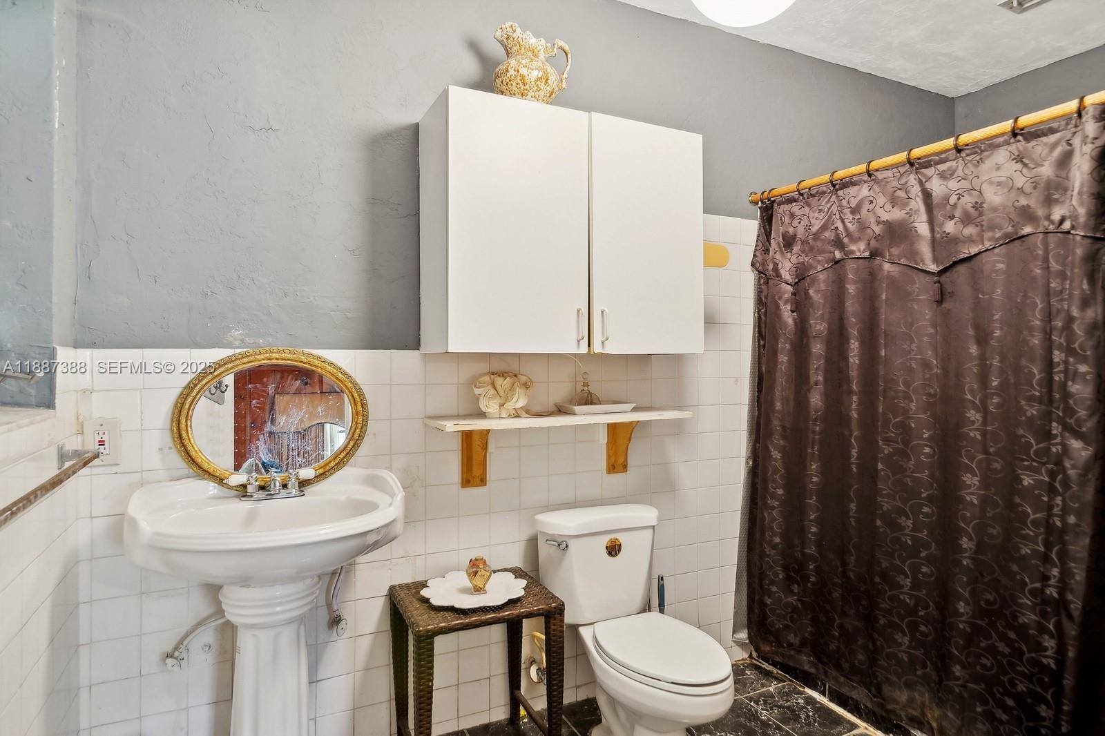 469 Northwest 69th Street Miami, FL 33150 - Photo 17 of 39 a bathroom with a toilet a sink and a mirror