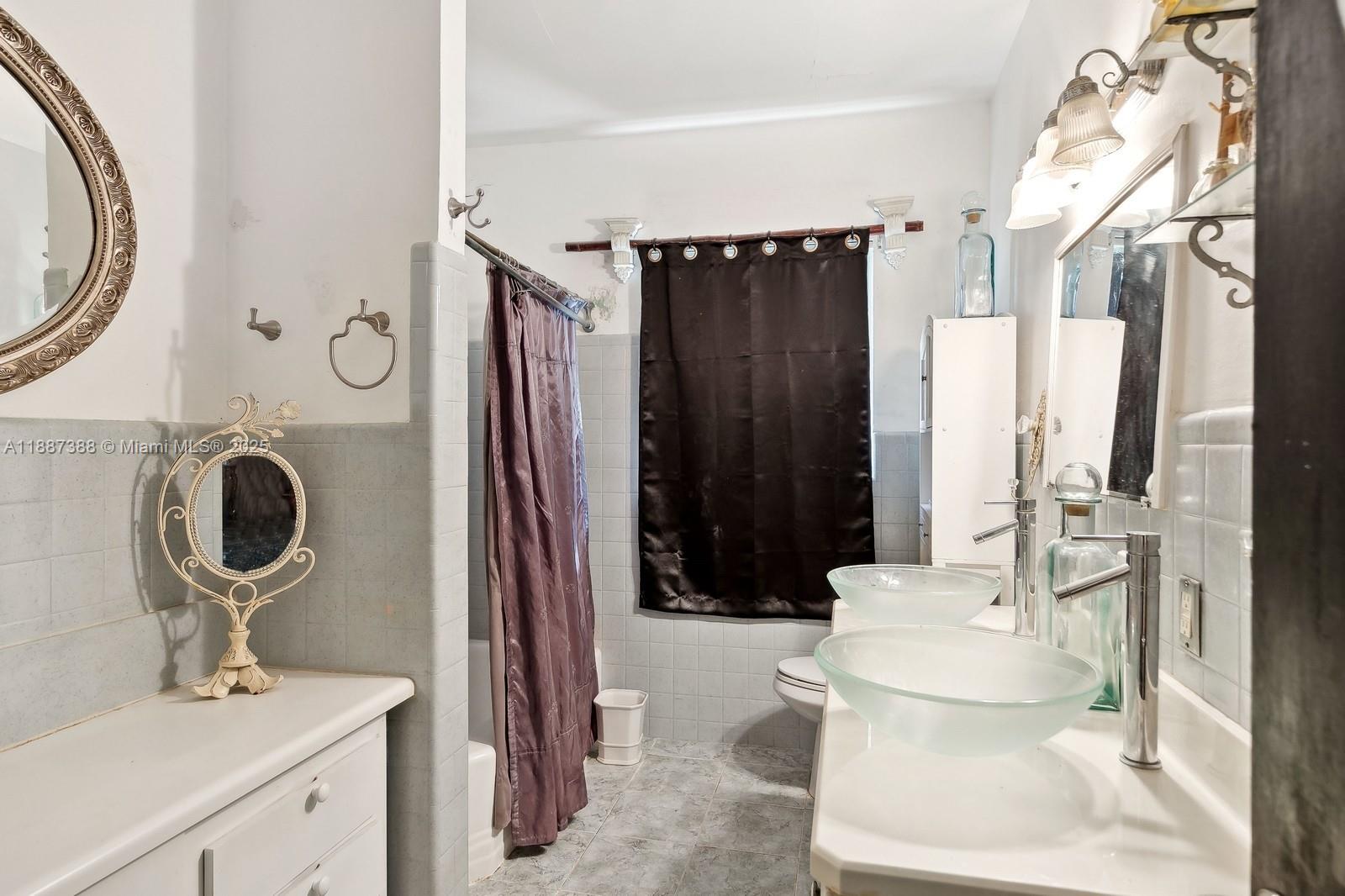 469 Northwest 69th Street Miami, FL 33150 - Photo 20 of 39 a bathroom with a toilet sink and mirror