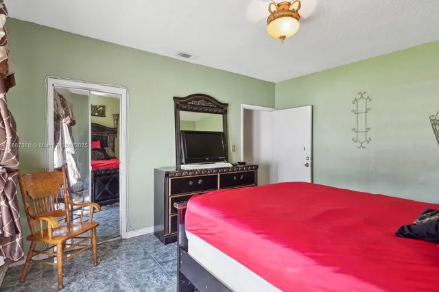 a bedroom with a bed and a flat screen tv