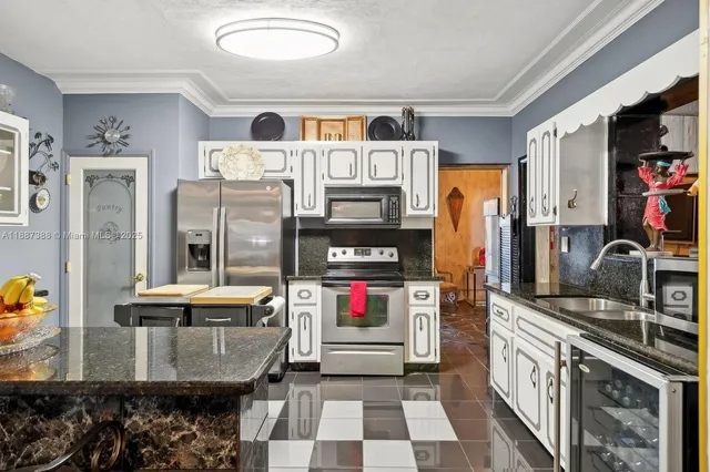 a kitchen with stainless steel appliances kitchen island granite countertop a refrigerator and a stove