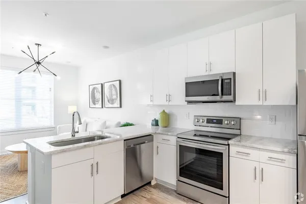 a kitchen with stainless steel appliances a stove a sink and a microwave