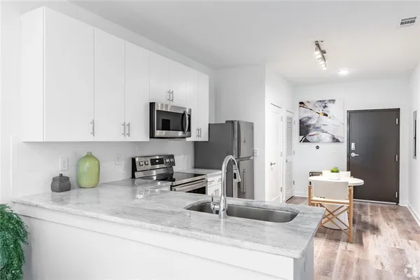 a kitchen with stainless steel appliances granite countertop a sink a stove and a refrigerator