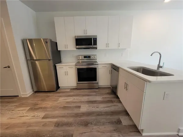 a kitchen with white cabinets sink and stainless steel appliances