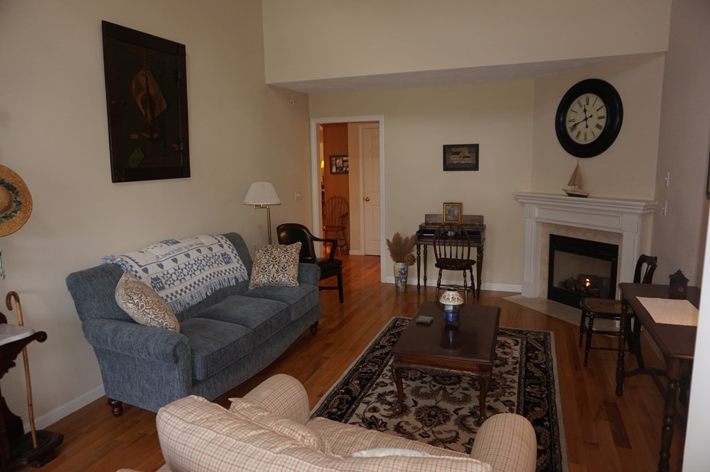 29 Riley Road, Unit 29 Lunenburg, MA 01462 - Photo 6 of 35 a living room with furniture a clock and a fireplace