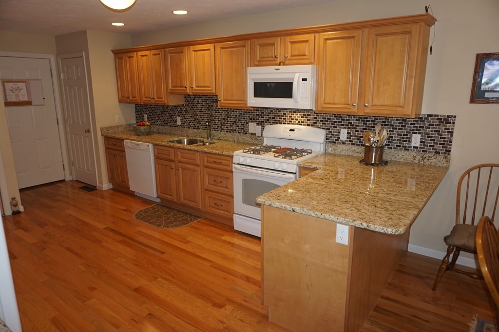 29 Riley Road, Unit 29 Lunenburg, MA 01462 - Photo 8 of 35 a kitchen with stainless steel appliances granite countertop a stove a sink and a microwave