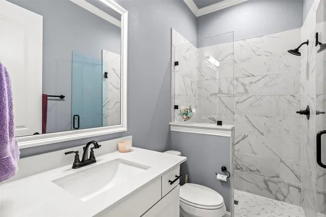 a bathroom with a sink toilet vanity and shower