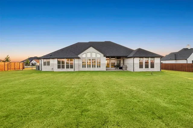 a view of a big house with a big yard and large trees