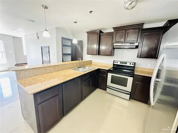 a kitchen with stainless steel appliances granite countertop a sink stove and refrigerator