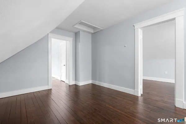 a view of an empty room with wooden floor