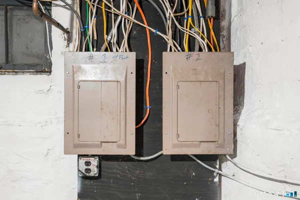 a view of a white house with a large tree