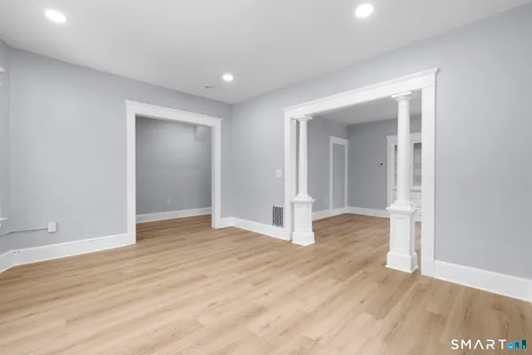 an empty room with wooden floor & windows and closet