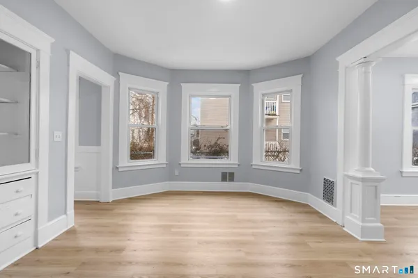 a view of a kitchen with wooden floor and a refrigerator