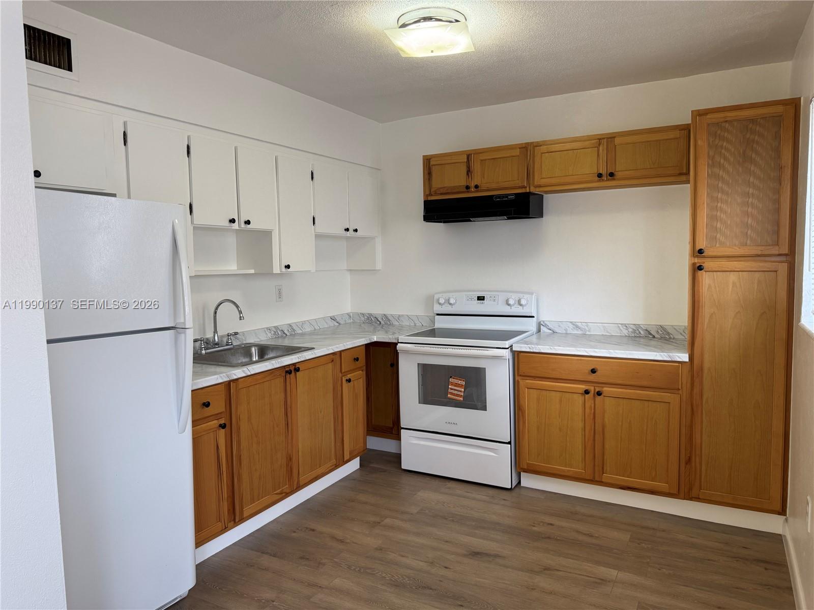 a kitchen with stainless steel appliances a refrigerator sink and cabinets