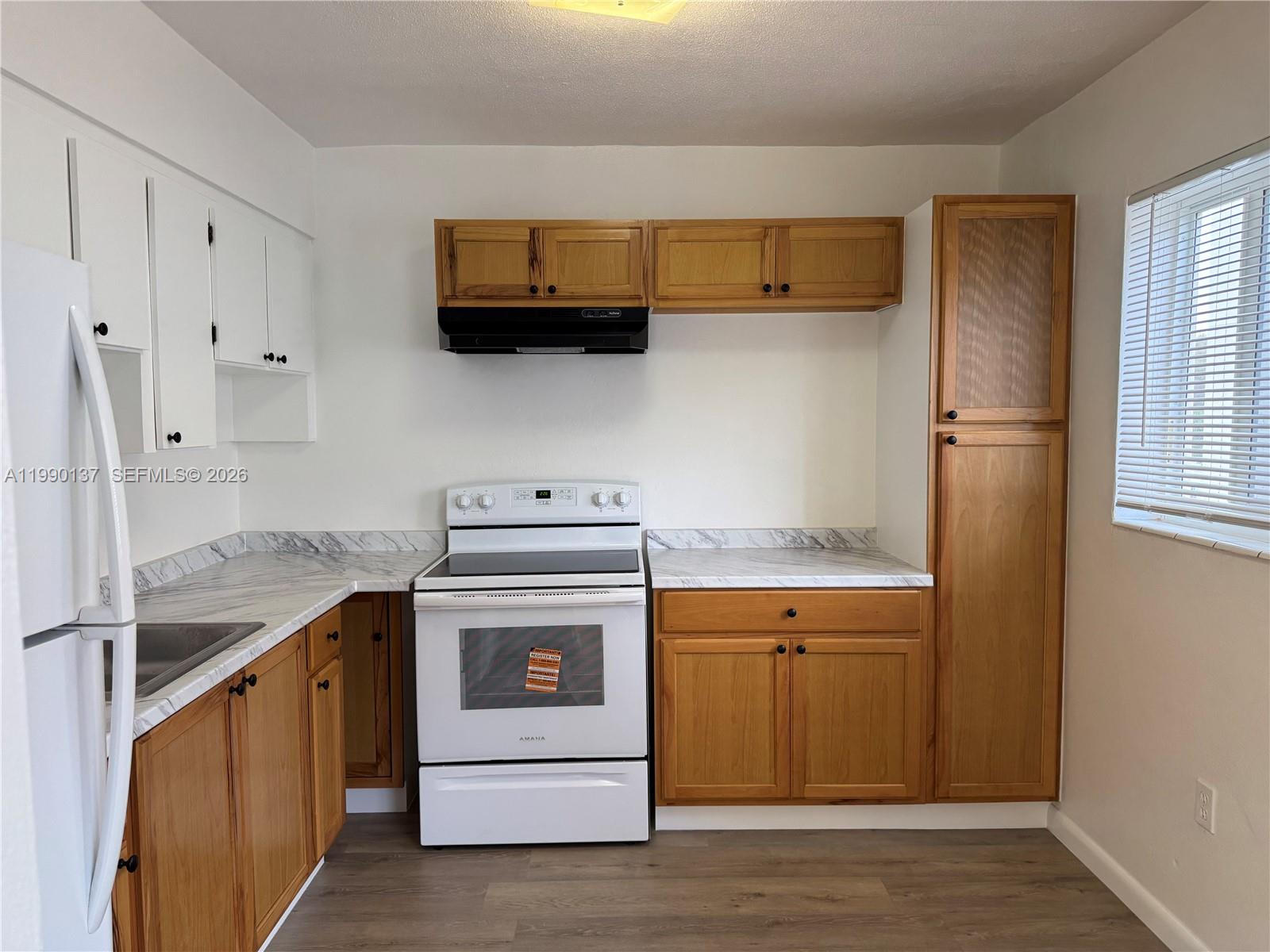 4080 Southwest 2nd Terrace, Unit 6 Miami, FL 33134 - Photo 2 of 14 a utility room with stainless steel appliances wooden floor sink and stove