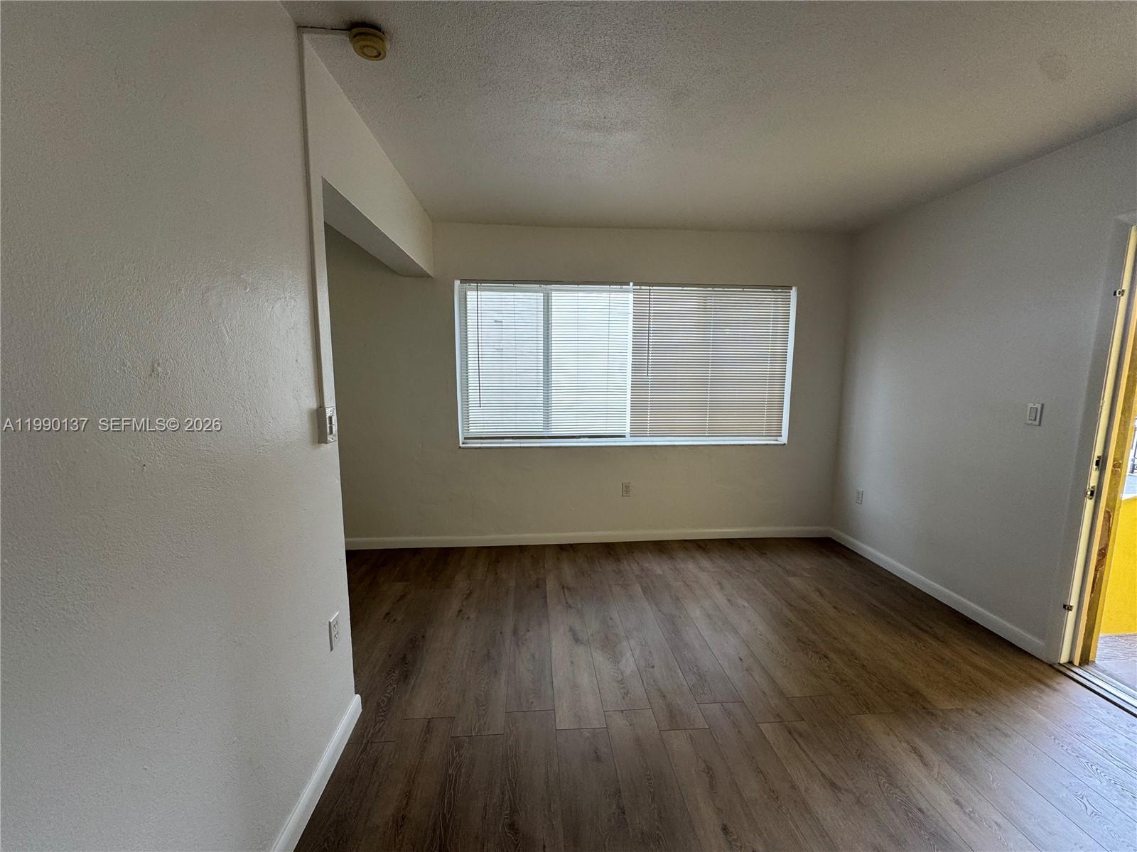 4080 Southwest 2nd Terrace, Unit 6 Miami, FL 33134 - Photo 5 of 14 an empty room with wooden floor and windows