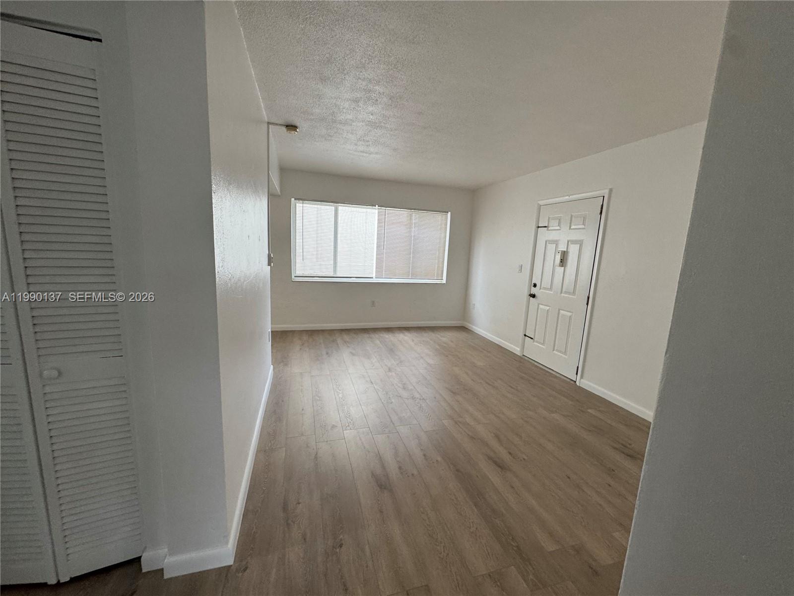 4080 Southwest 2nd Terrace, Unit 6 Miami, FL 33134 - Photo 6 of 14 an empty room with wooden floor and windows