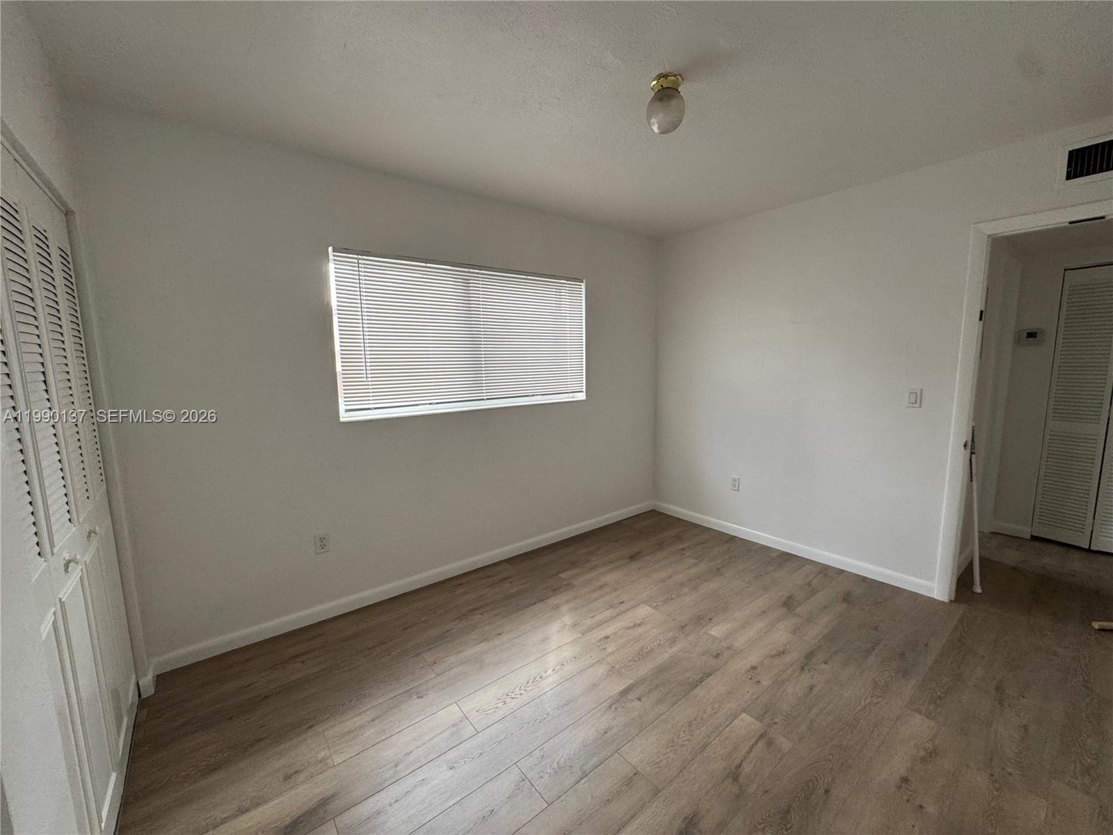 4080 Southwest 2nd Terrace, Unit 6 Miami, FL 33134 - Photo 7 of 14 an empty room with wooden floor and windows