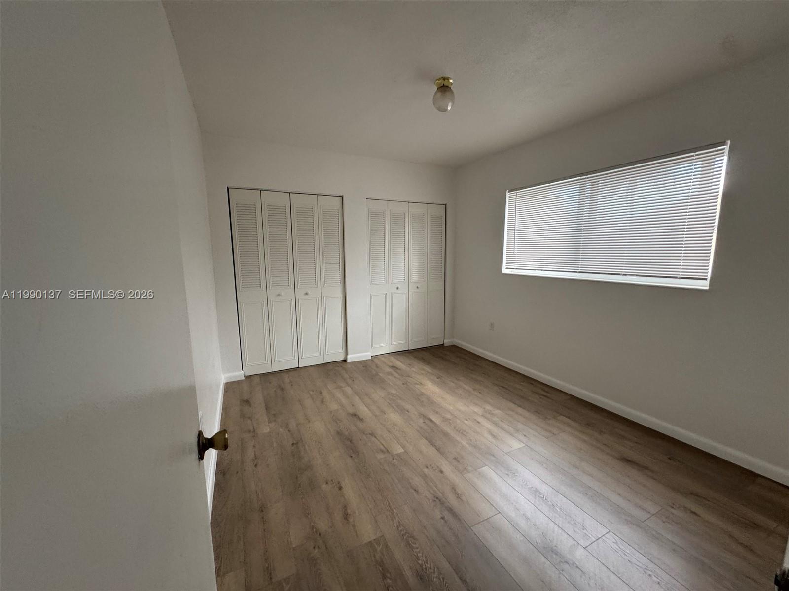 4080 Southwest 2nd Terrace, Unit 6 Miami, FL 33134 - Photo 9 of 14 a view of an empty room with wooden floor and a window