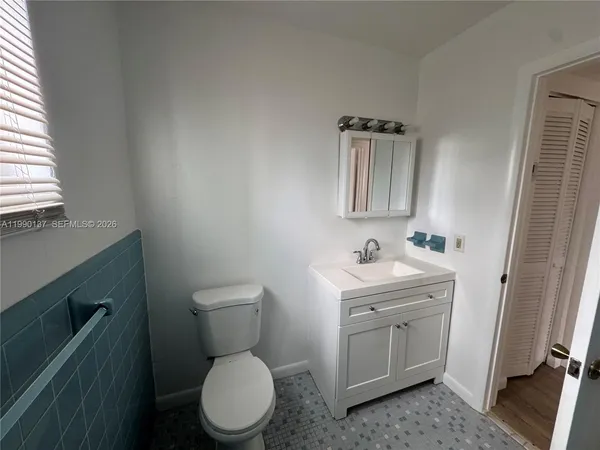 a bathroom with a toilet a sink and mirror