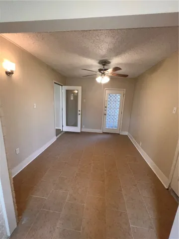 an empty room with a ceiling fan and window