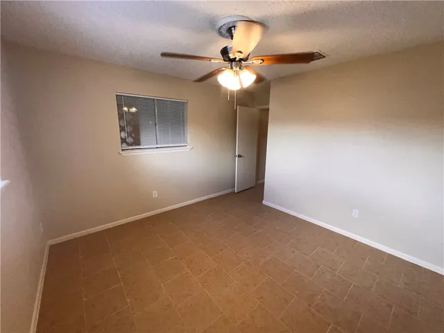 an empty room with closet and a chandelier fan