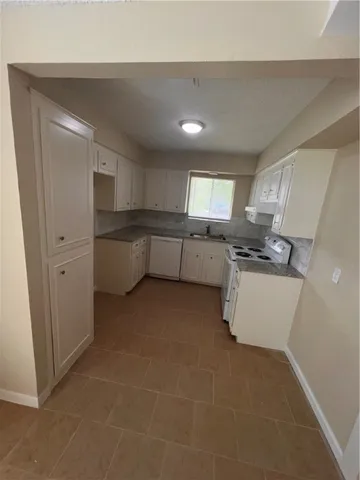 a kitchen with a refrigerator and a stove top oven