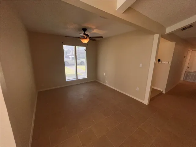 a large white kitchen with a sink a refrigerator and white cabinets