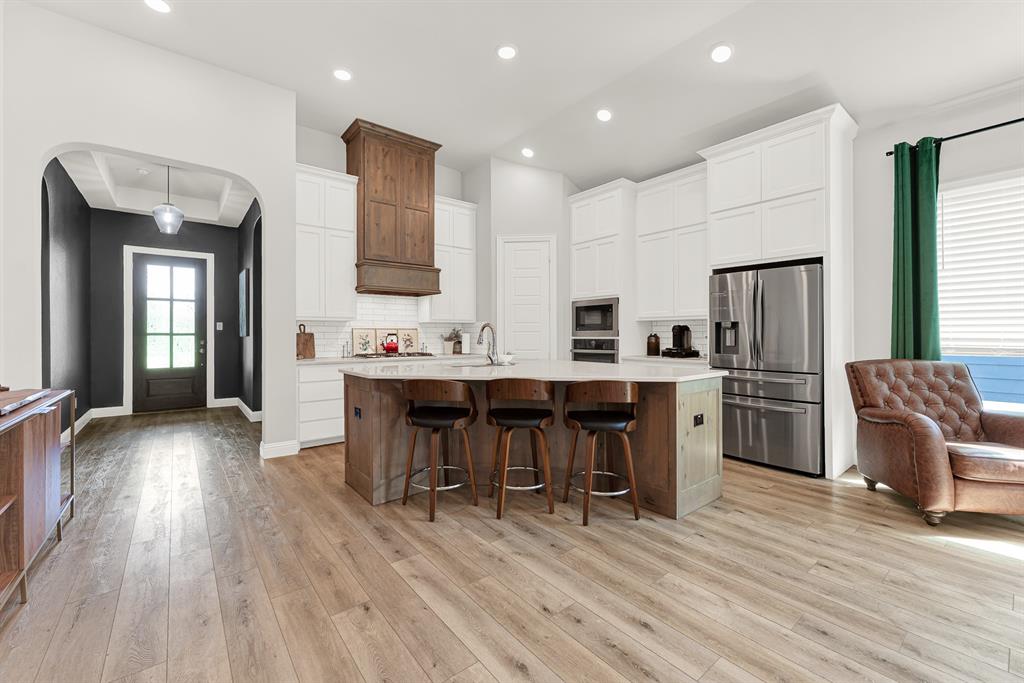 6404 Trezevant Street Rowlett, TX 75089 - Photo 5 of 30 a open kitchen with stainless steel appliances kitchen island granite countertop a refrigerator a stove a sink a dining table and chairs with wooden floor