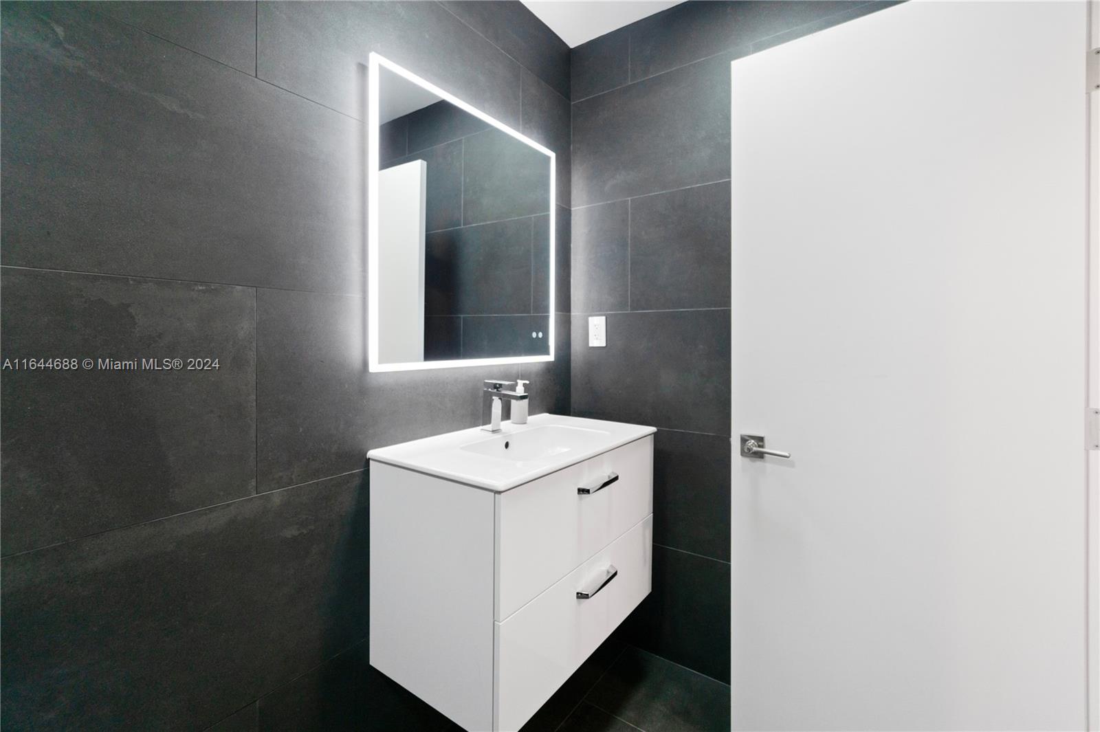 100 Lincoln Road, Unit 1104 Miami Beach, FL 33139 - Photo 11 of 24 a bathroom with a sink and a mirror