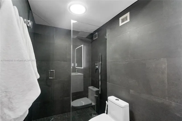 a bathroom with a toilet and a shower
