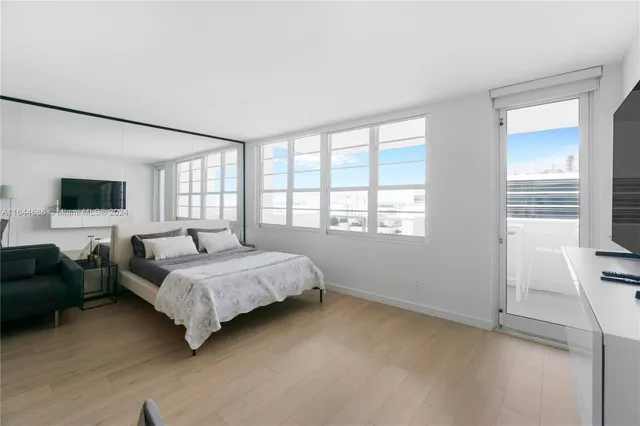 a living room with furniture a flat screen tv and a window