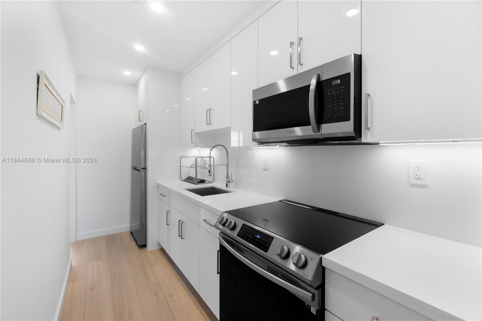 100 Lincoln Road, Unit 1104 Miami Beach, FL 33139 - Photo 22 of 24 a kitchen with a stove and a microwave