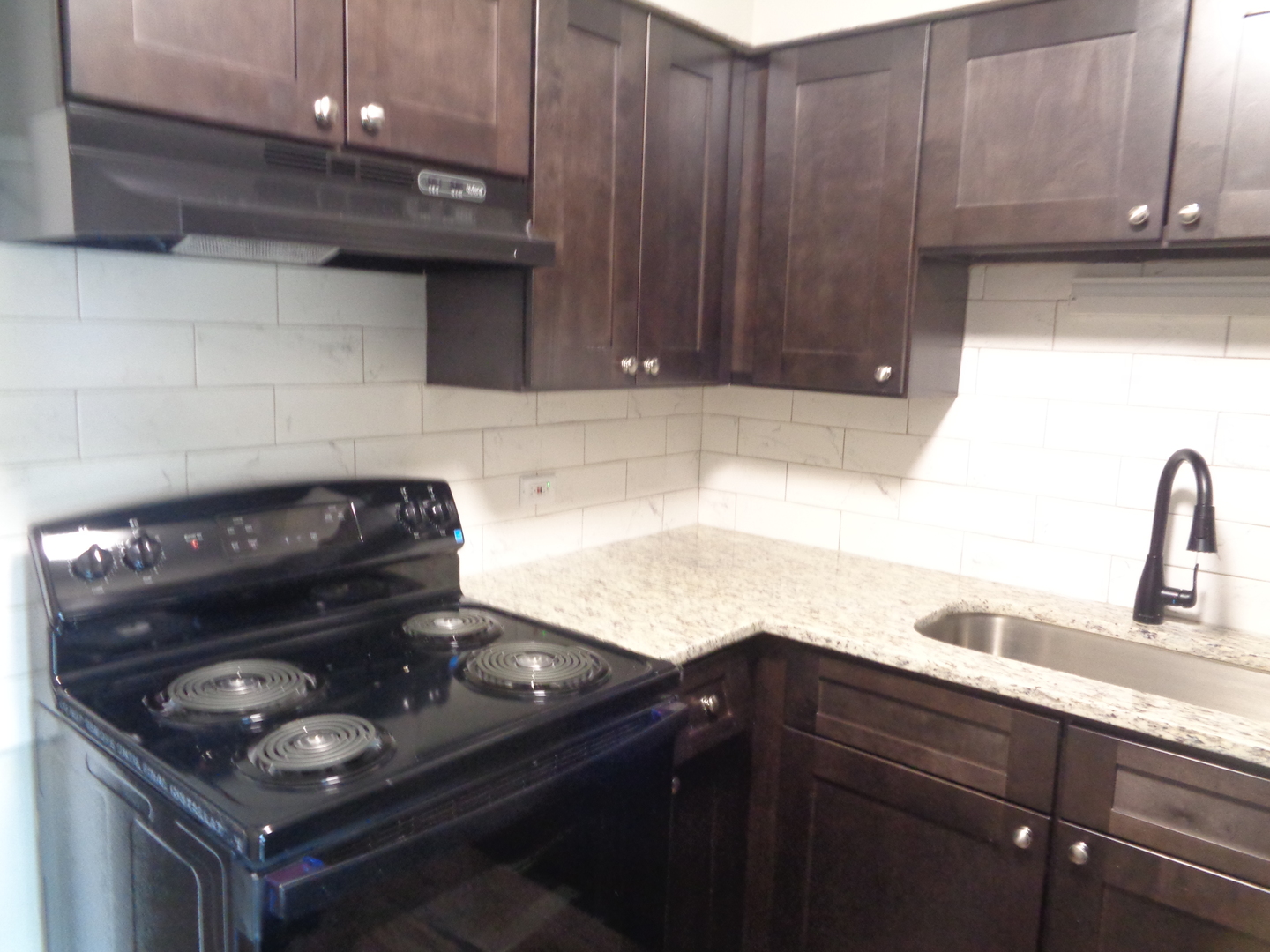 1340 North Main Street, Unit C4 Wheaton, IL 60187 - Photo 3 of 8 a kitchen with granite countertop a stove and a sink
