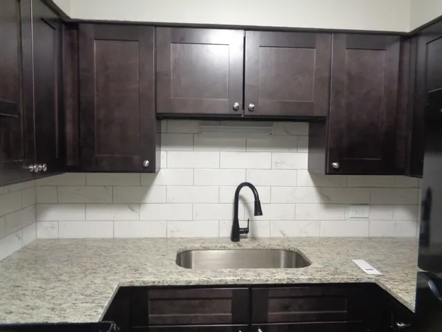 a kitchen with granite countertop wooden cabinets and granite counter