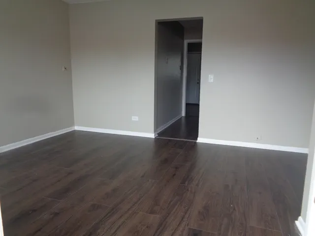 an empty room with wooden floor and closet