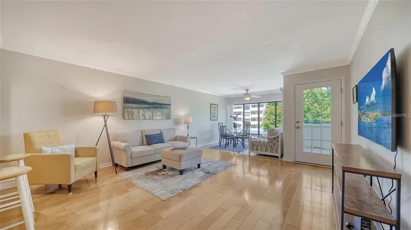 a living room with furniture a window and a flat screen tv